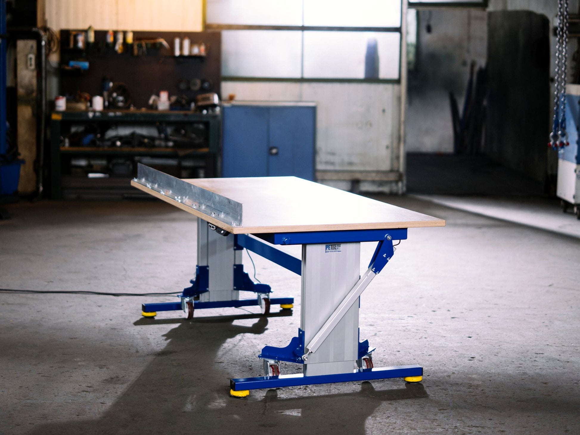 Height-adjustable industrial table with casters and tilting tabletop